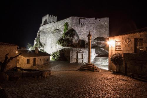 a large castle at night with a street light at Casas da Lagariça in Sortelha
