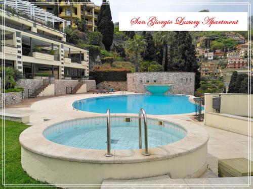 タオルミーナにあるSan Giorgio Luxury Apartment Taormina-Panoramic Pool & Parking Spaceの建物前の大型スイミングプール