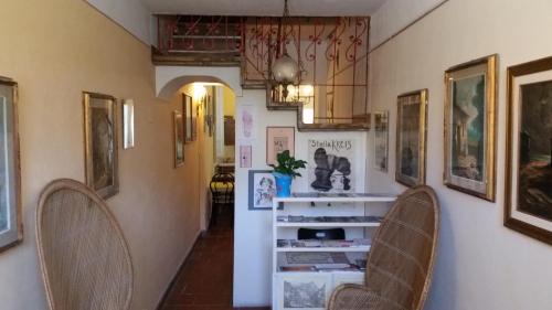 a hallway with two chairs and pictures on the walls at Grandpa Mau in Lucca