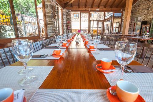 a long table in a restaurant with wine glasses at Hotel Rural La Bolera in Robles de Laciana