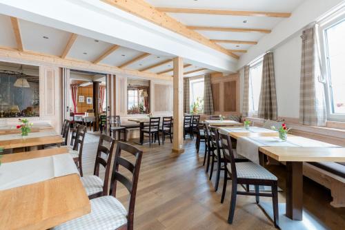 a restaurant with wooden tables and chairs at Gasthof - Hotel Kopf in Riegel am Kaiserstuhl