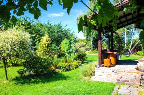 a garden with a pergola in the grass at Chata na końcu świata in Rzuchowa