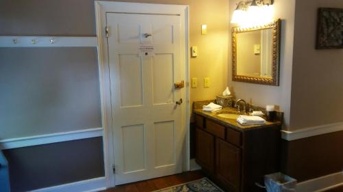 a bathroom with a sink and a mirror at Old Brick Inn in Saint Michaels