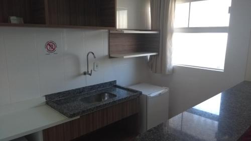 a small kitchen with a sink and a window at Lacqua diRoma 1 - Apartamentos JN in Caldas Novas