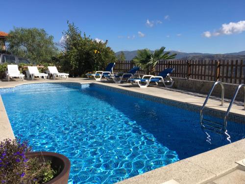 a swimming pool with blue chairs at Casa de Mos in Aboim