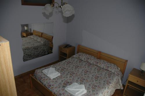 a small bedroom with two beds and a mirror at Hotel Valentino in Perosa Argentina
