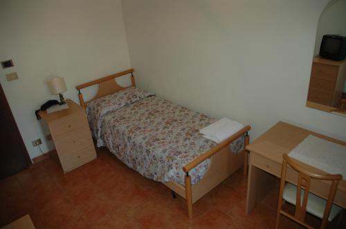 a small bedroom with a bed and a desk at Hotel Valentino in Perosa Argentina