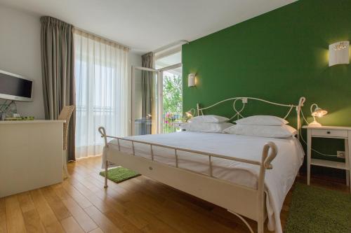 Un dormitorio con una pared verde y una cama en VILLA STEFANIJA small Boutique hotel&restaurant, en Barban