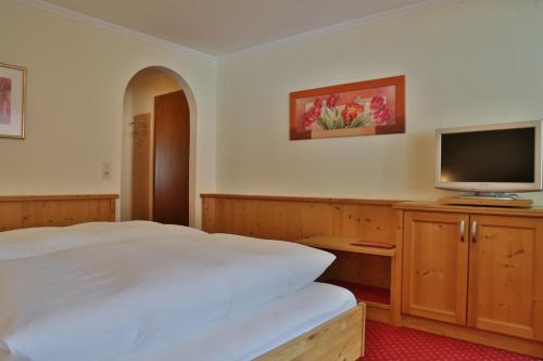 a bedroom with a bed and a flat screen tv at Haus Waldheim in Tux