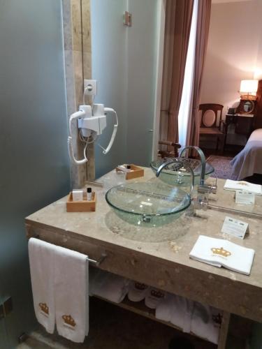 een badkamer met een glazen wastafel op een aanrecht bij Hotel Ibn-Arrik in Coimbra