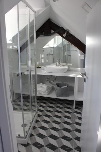 a white bathroom with a sink and a mirror at Guest House Santa Clara in Coimbra