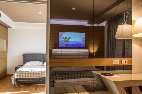 a bedroom with a bed and a tv on a wall at Grand Chalet delle Rocche in Rocca di Mezzo