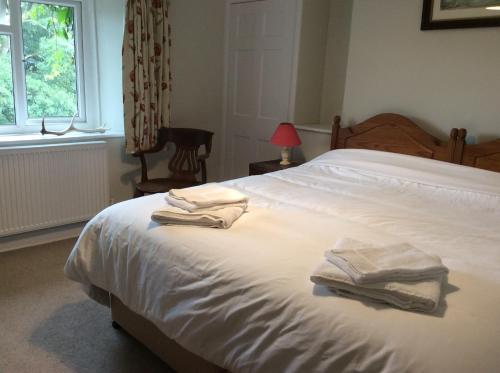 a bedroom with a bed with two towels on it at Zeal Farm in Dulverton