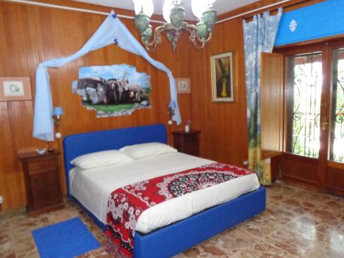 1 dormitorio con 1 cama con cabecero azul en B&B Villa Tina, en Alfedena