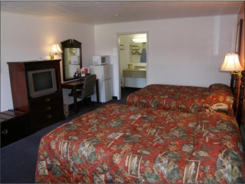 a hotel room with two beds and a television at Red Lion Motor Lodge in Havana