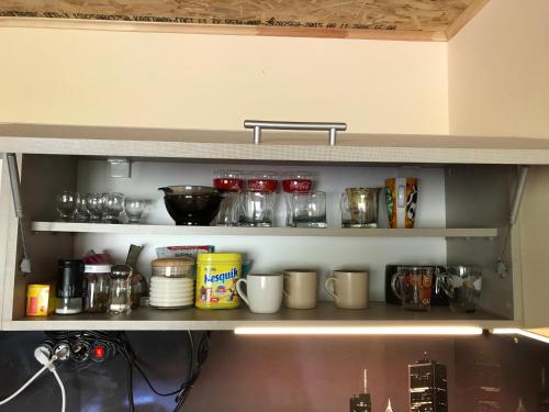 a kitchen shelf with jars and other items on it at Room 46 in Gudauri