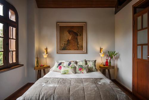 a bedroom with a large bed with pillows at Casa da Estacao - A casa mais charmosa de Morretes! in Morretes