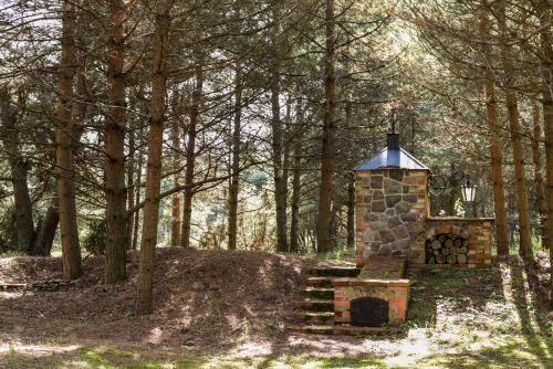 a stone fireplace in the middle of a forest at Sunset House in Ulmale