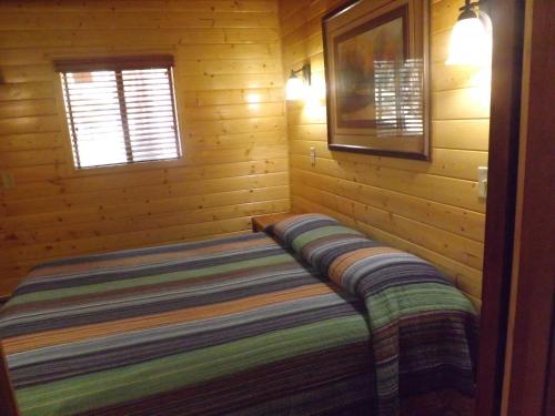 a bed in a log cabin with a window at Arizona Mountain Inn & Cabins in Flagstaff
