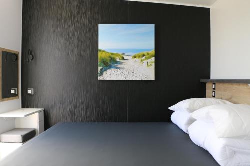 ein Schlafzimmer mit einem Bett und einem Bild von einem Strand in der Unterkunft Stadscamping Zeeland in Middelburg