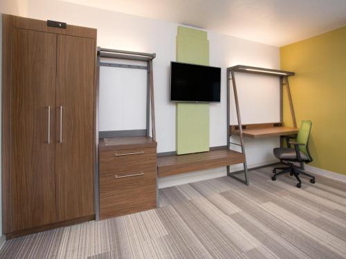a room with a tv and a cabinet and a chair at Holiday Inn Express & Suites - Gettysburg by IHG in Gettysburg