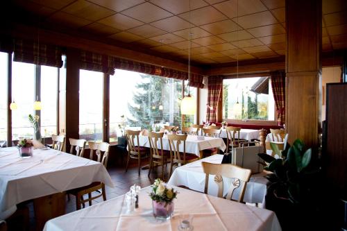 a restaurant with white tables and chairs and windows at Restaurant-Hotel Maien in Lörrach
