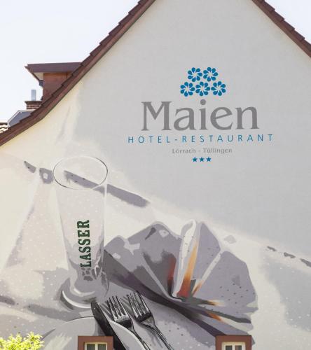 a sign for a hotel restaurant with a glass at Restaurant-Hotel Maien in Lörrach