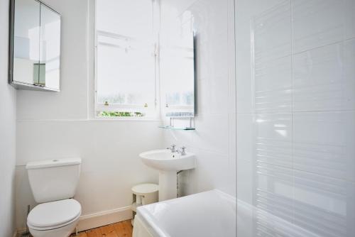 a white bathroom with a toilet and a sink at Comely Bank Apartment in Edinburgh