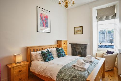 a bedroom with a bed with towels on it at Comely Bank Apartment in Edinburgh