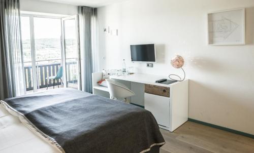 a bedroom with a bed and a desk and a window at Restaurant-Hotel Maien in Lörrach