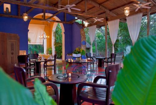 a restaurant with tables and chairs in a room at Hacienda San Jose Cholul in Tixkokob