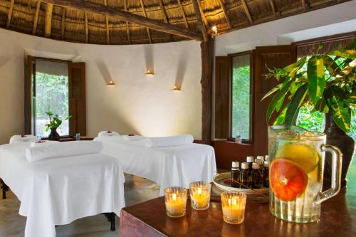 a dining room with white tables and a vase with fruit at Hacienda San Jose Cholul in Tixkokob