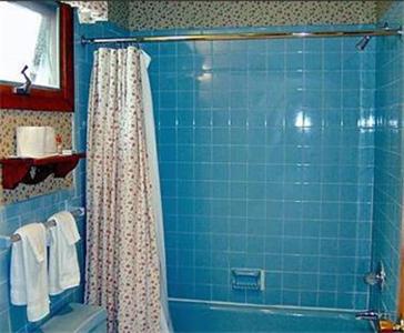 a bathroom with a shower curtain and a blue and white tiled floor at West Road Motel in Bennington