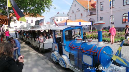 a small blue train with people riding on it at Ystad Holiday Houses in Ystad