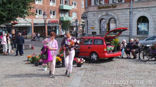 two women are walking down a street with flowers at Ystad Holiday Houses in Ystad