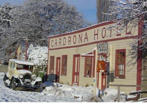 a truck parked in front of a building in the snow at Cardrona Ski Apartment in Wanaka