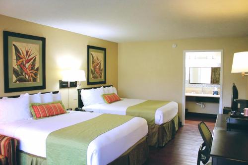 a hotel room with two beds and a desk at Residence Hub Inn and Suites in Marianna