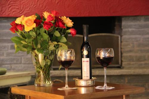 a table with two glasses of wine and a vase of flowers at Hotel Hochfirst in Lenzkirch