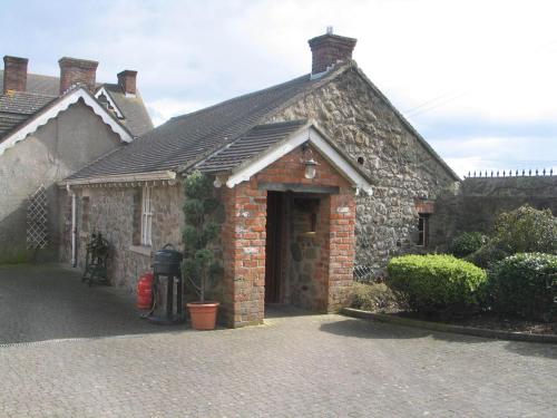 a brick building with a door and a driveway at Clenaghans in Moira