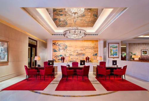 シンガポールにあるThe St. Regis Singaporeの赤い椅子と大きな絵画が飾られたダイニングルーム