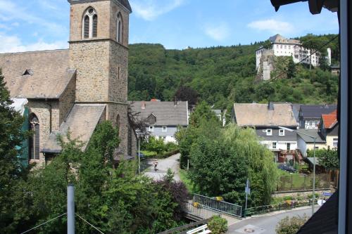 an old church with a clock tower in a town at Pension / Ferienwohnung Allebrodt in Lennestadt
