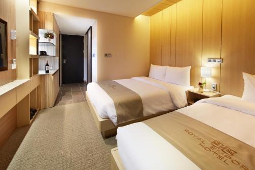 a hotel room with two beds and a television at Royal Emporium Incheon Airport in Incheon