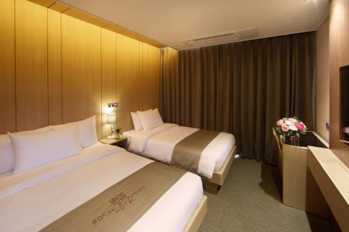 a hotel room with two beds and a television at Royal Emporium Incheon Airport in Incheon