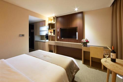 a hotel room with a bed and a television at Royal Emporium Incheon Airport in Incheon