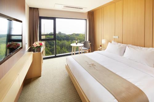a hotel room with a large bed and a large window at Royal Emporium Incheon Airport in Incheon