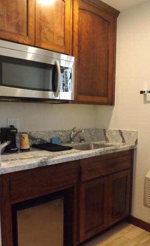 a kitchen with a sink and a microwave at Shoshone Inn in Shoshone