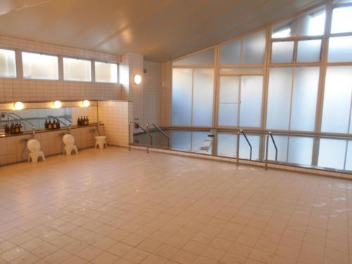 a large room with a tile floor and large windows at Renaissance Tanagura in Shirakawa
