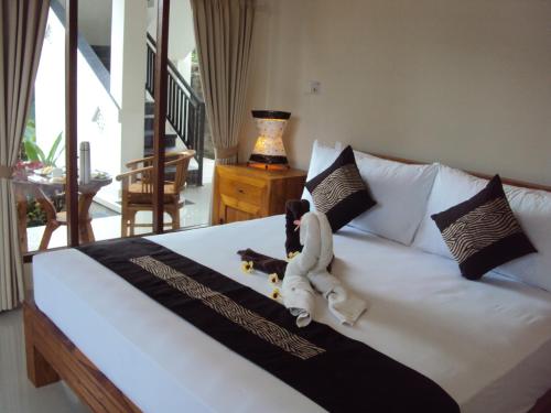 a stuffed animal is sitting on a bed at Soka Homestay in Ubud