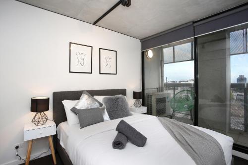 a bedroom with a large white bed and a large window at StayCentral - NGV Arts Centre Retreat Southbank in Melbourne