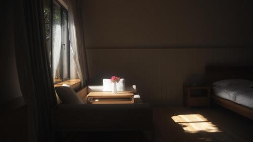 a room with a table with a chair and a window at Zen Box House in Yangshuo
